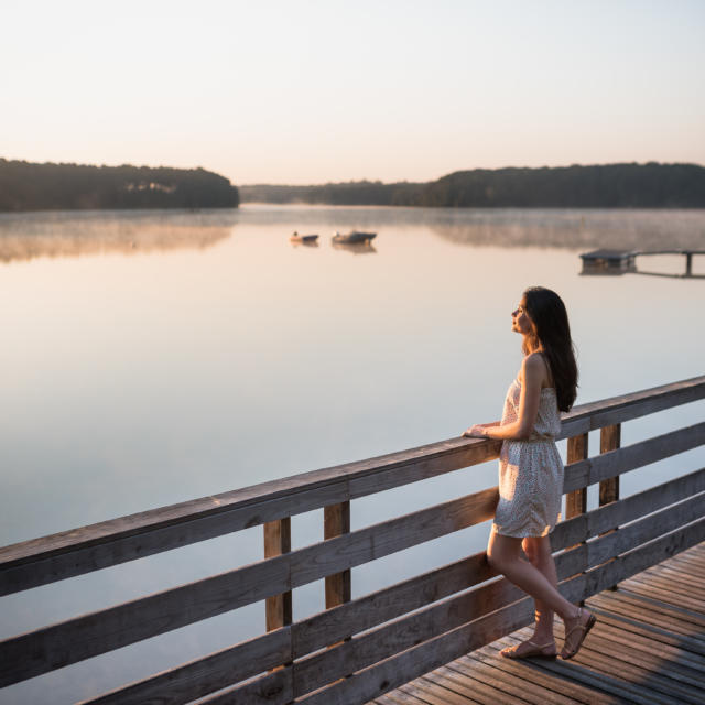 Une jeune femme au lever du soleil sur le lac de Trémelin